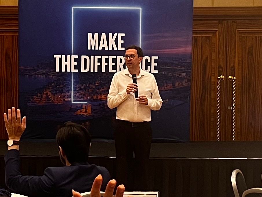 Neill Harvey-Smith speaking on stage in front of a Make the Difference backdrop